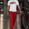 Man draagt het witte #STOUT Sketch Kiss T-Shirt in een parkeergarage