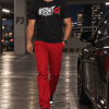 Man draagt het zwarte #STOUT Sketch Kiss T-Shirt in een parkeergarage